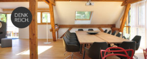 Denkraum “Das Herz“ Raum mit Konferenztisch, Sitzecke und Küche. Blick aus der Küche auf den Konferenztisch