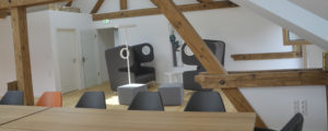 Denkraum “Das Herz“ Raum mit Konferenztisch, Sitzecke und Küche. Blick auf Sitzecke und Türe.